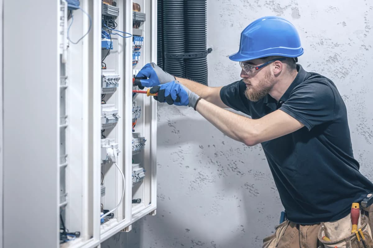Electrician at work in an open distribution board